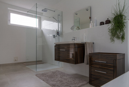 Blick auf Badezimmermoebel aus Holz und begehbare Dusche.jpg