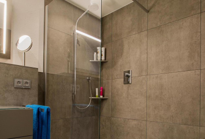 Blick in die rechteckige ebenerdige Dusche mit eckigen Fliesen an der Wand.jpg