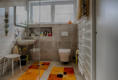 Blick ins Bad auf WC und Waschbecken mit hoeher gelegten Fenstern.jpg